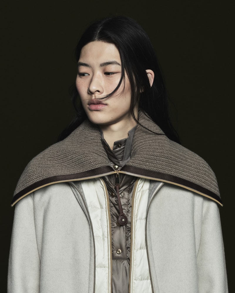 Moncler Pre-Fall 2026 knit shawl layered over a lightweight down jacket.