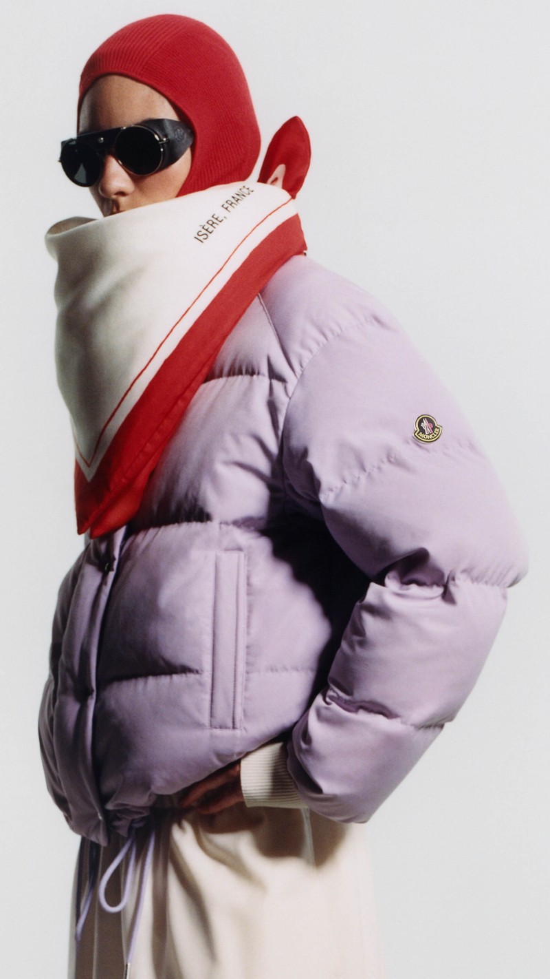 Moncler Re/Icons 2026, lilac Verone down jacket, red balaclava, printed scarf and black sunglasses.