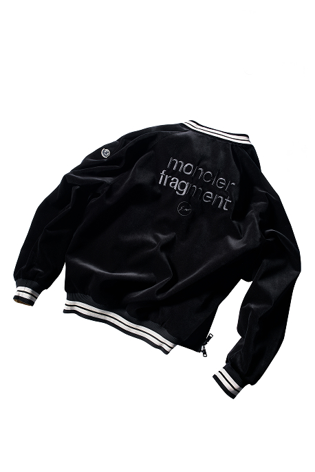Moncler x Fragment, black jacket with logo on the back and on the sleeve, with black and white striped details. 