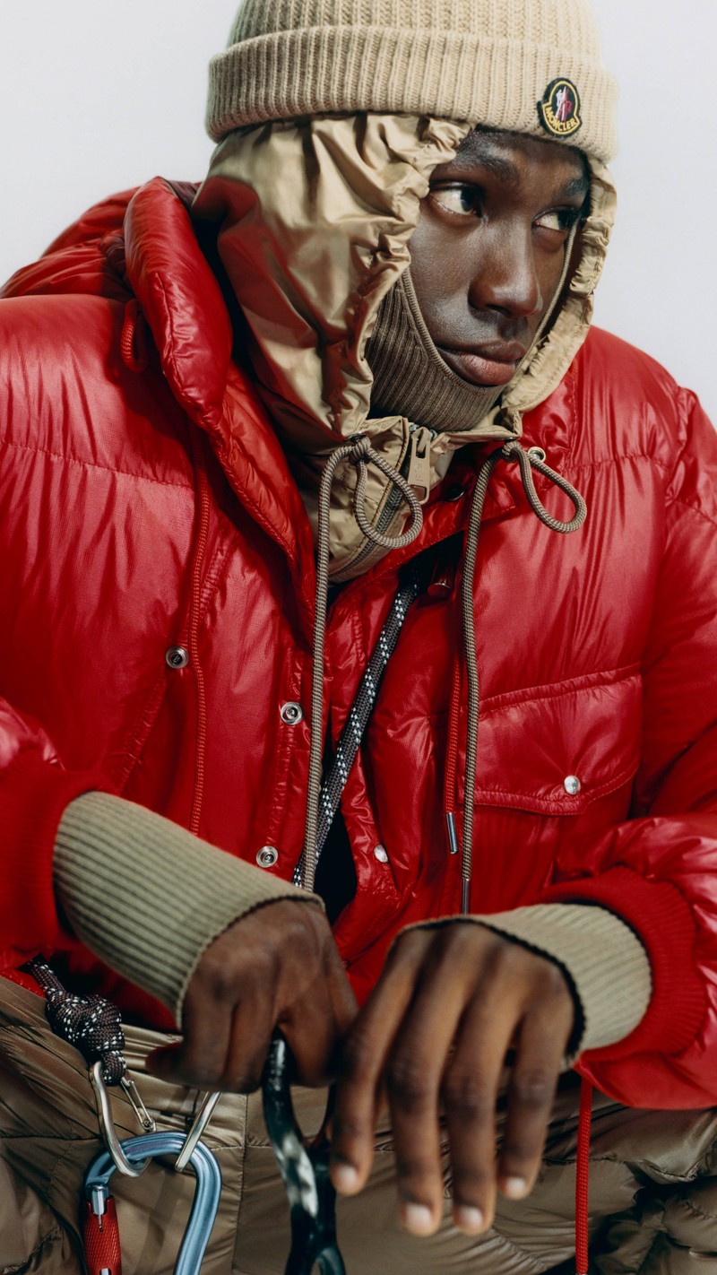 Moncler Re/Icons 2026, red Karakorum down jacket with beige hood, ribbed balaclava and logo beanie.