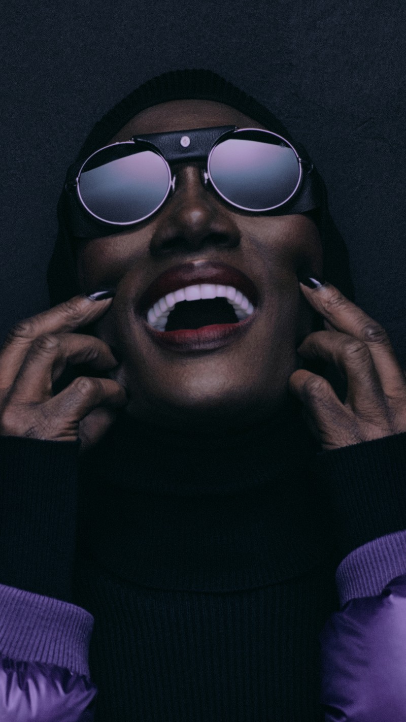 Moncler Re/Icons 2026, behind the scenes in black and white: Grace Jones in a glossy down jacket with the cast.