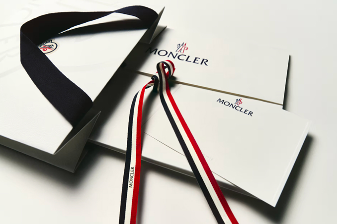 Moncler gift boxes and envelopes with tricolor and black ribbons.
