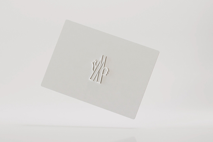 White Moncler gift card with embossed logo on a light background.
