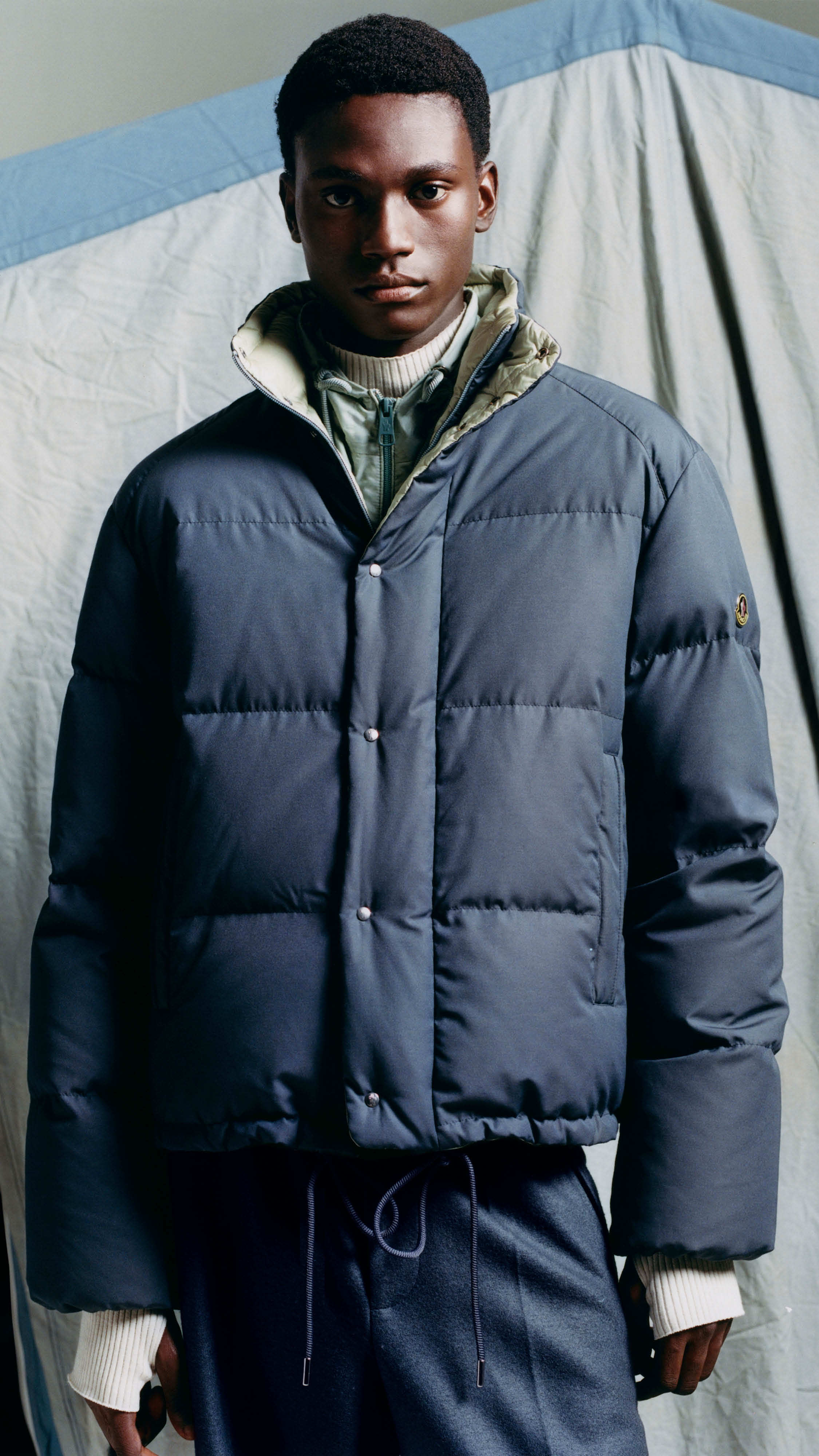 Moncler Re/Icons 2026, slate blue Verone down jacket and high-neck sweater.
