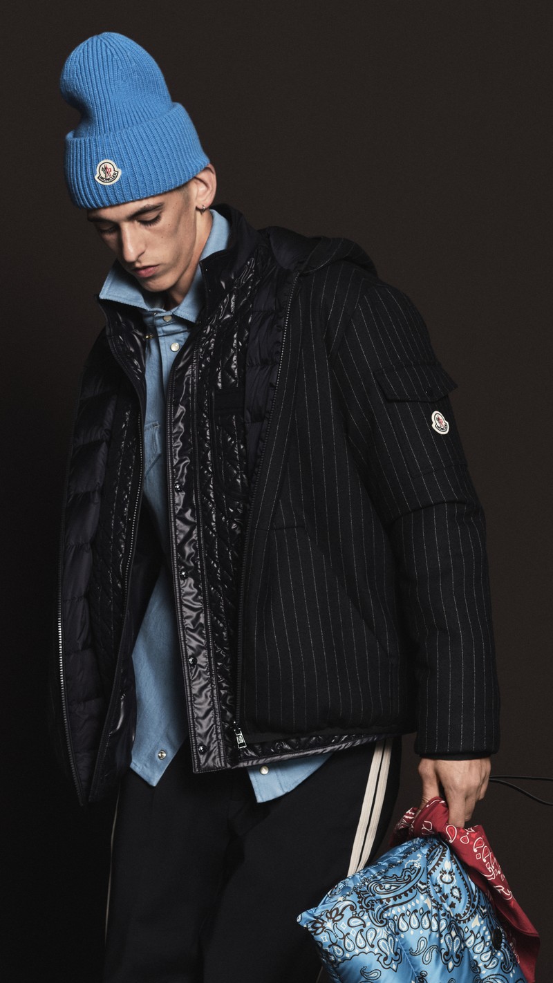 Moncler Pre-Fall 2026 : mannequin en doudoune noire brillante sur veste Ă fines rayures et chemise en denim