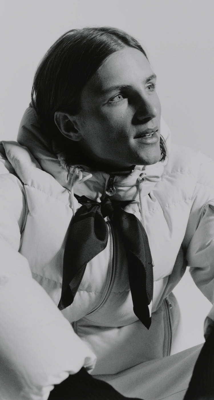 Moncler Re/Icons 2026, Himalaya. Camel down jacket and red balaclava, blue climbing rope.