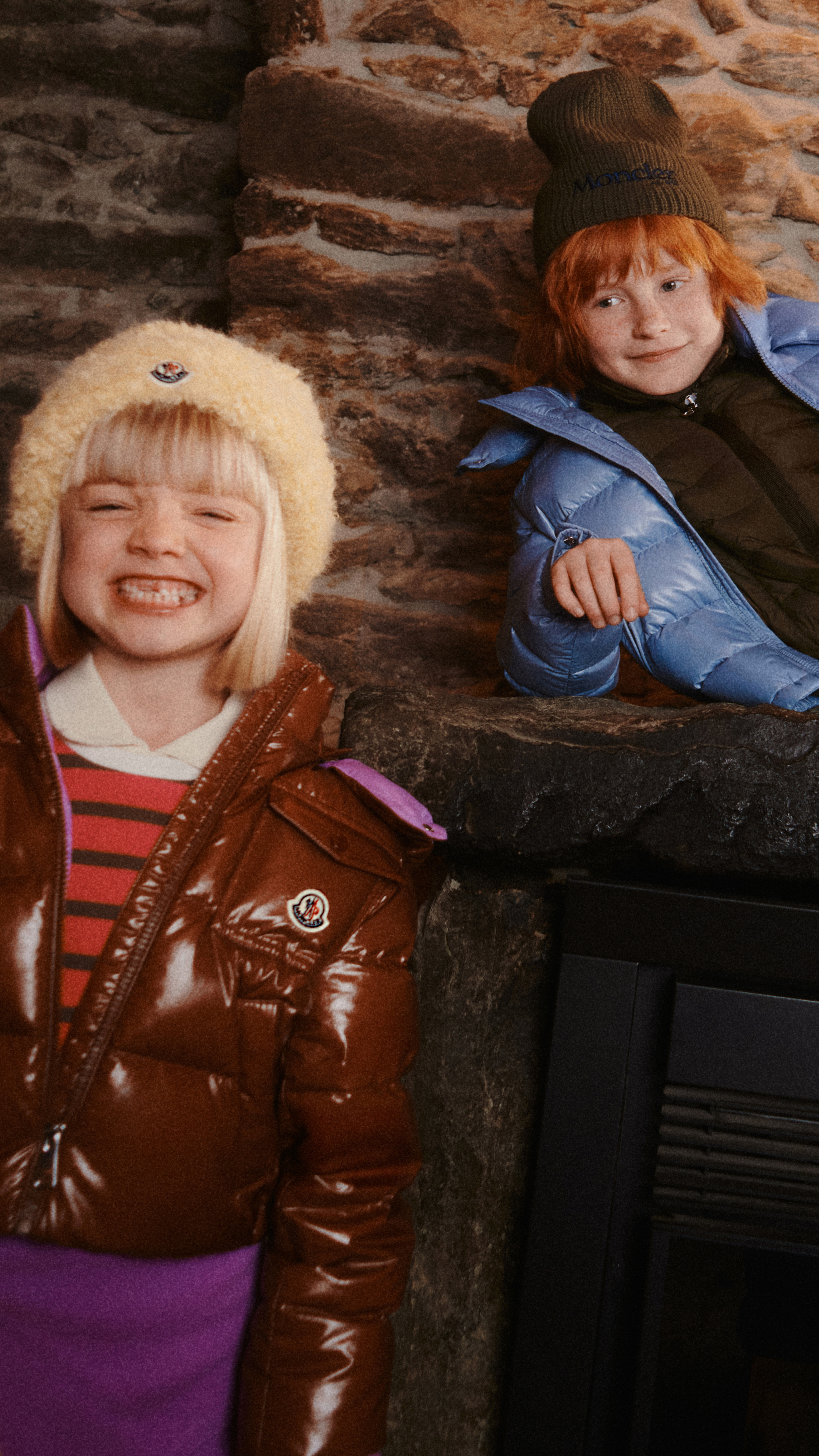 Moncler pour garçon et fille : doudoune marron, bonnet beige, pull rayé ; bonnet et sweat vert, doudoune bleue, jean.