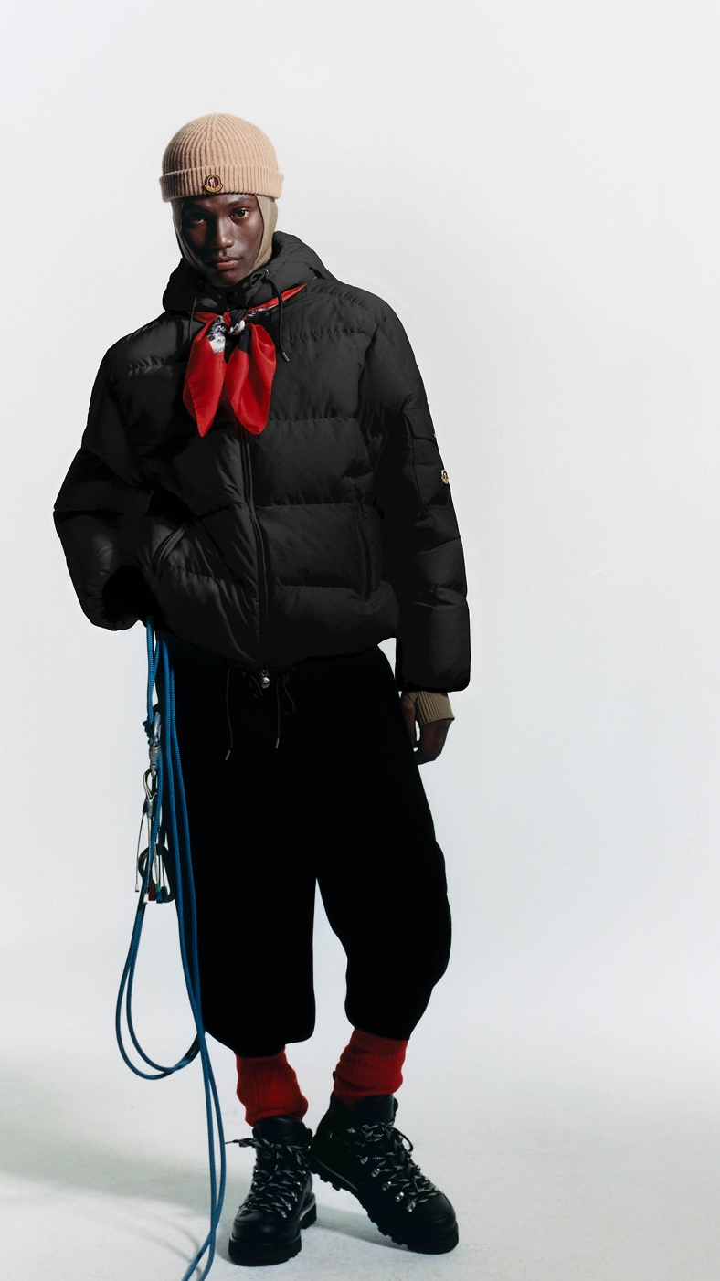 Moncler Re/Icons para hombre y mujer. Plumífero negro, pañuelo rojo y gorro beige.