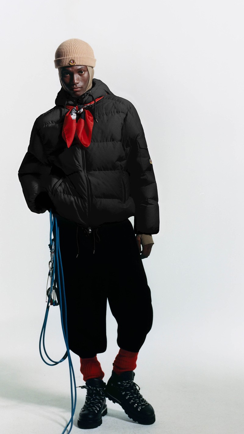 Moncler Re/Icons para hombre y mujer. Plumífero negro, pañuelo rojo y gorro beige.