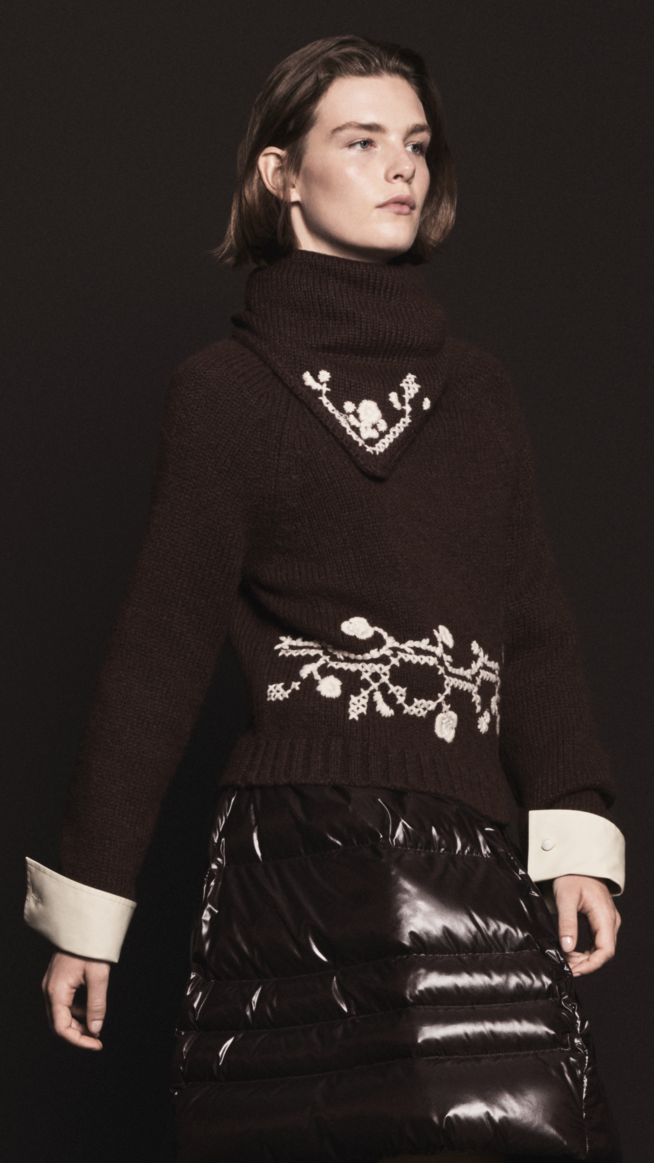 Moncler メンズとレディースのレディ・トゥ・ウェア。フラワー刺繍入りダークブラウンのタートルネックニット、光沢のあるダウンスカート。