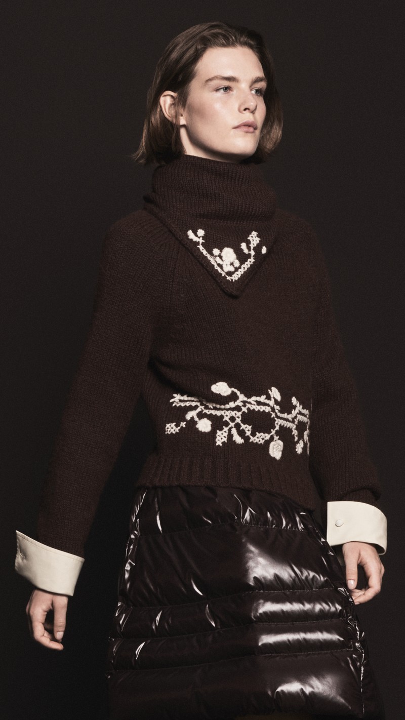 Moncler メンズとレディースのレディ・トゥ・ウェア。フラワー刺繍入りダークブラウンのタートルネックニット、光沢のあるダウンスカート。