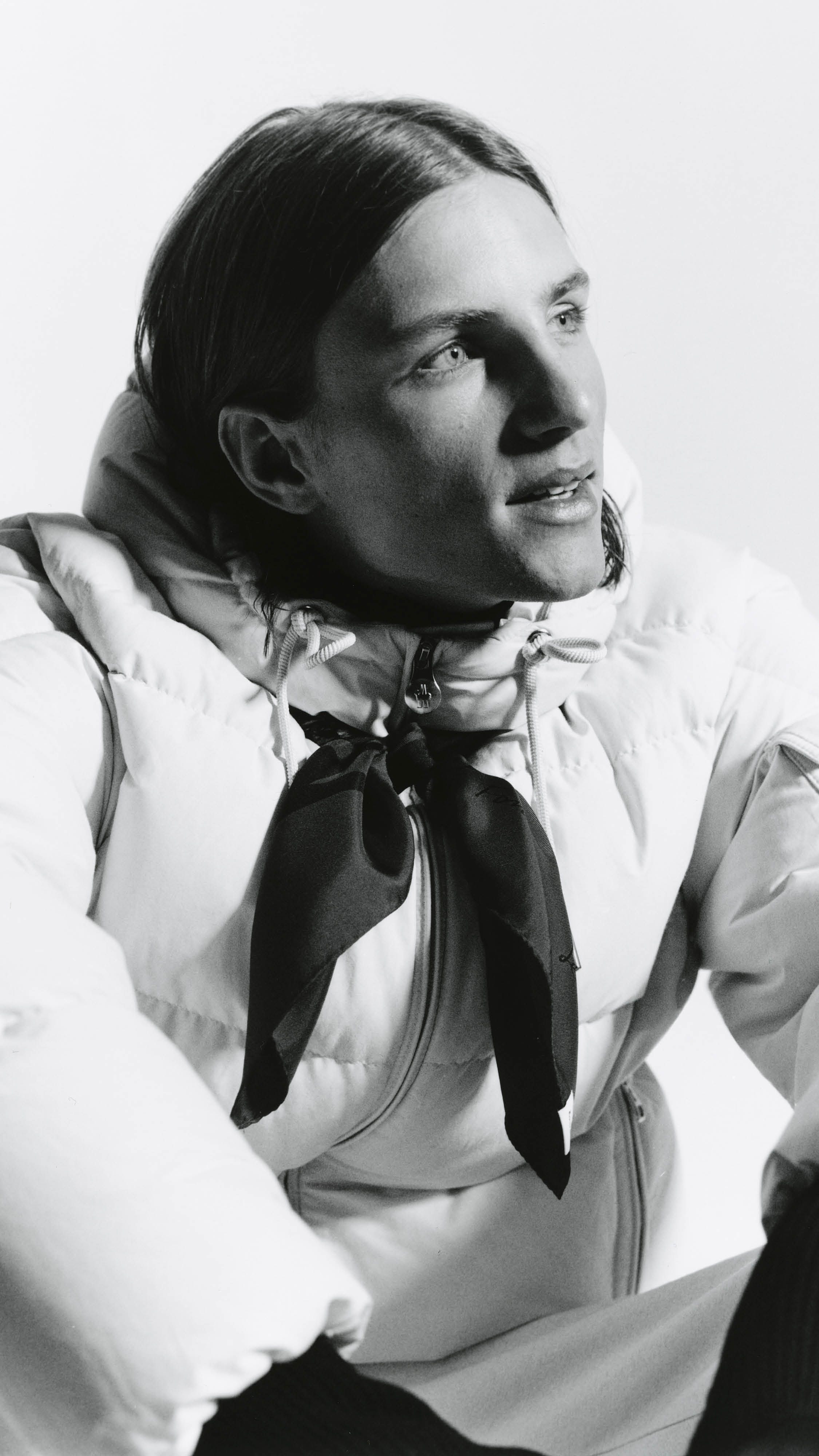 Moncler Re/Icons 2026, black and white portrait, light Himalaya down jacket and a knotted scarf.