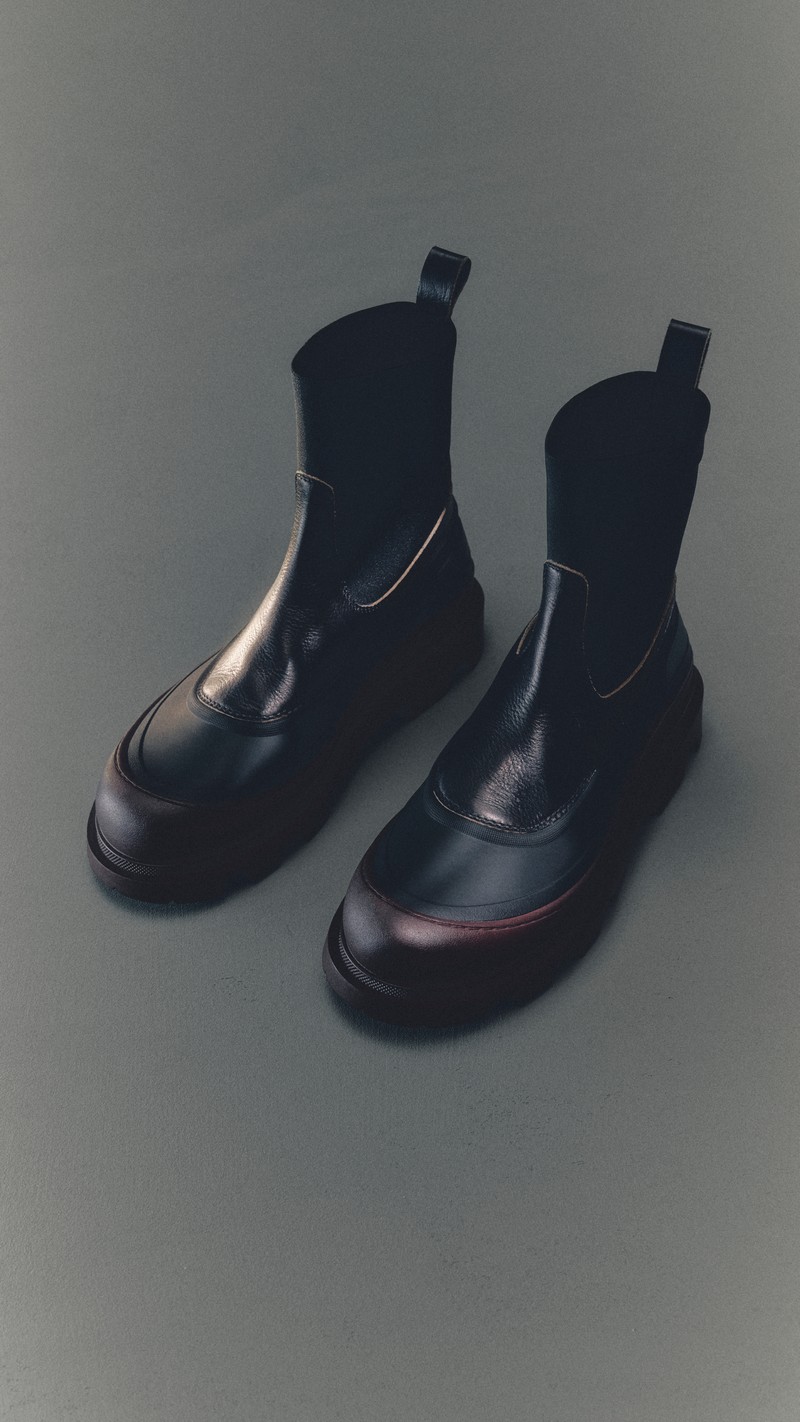 Moncler メンズ&ウィメンズシューズ。バーガンディのラバートゥキャップを備えたブラックレザーのアンクルブーツ。