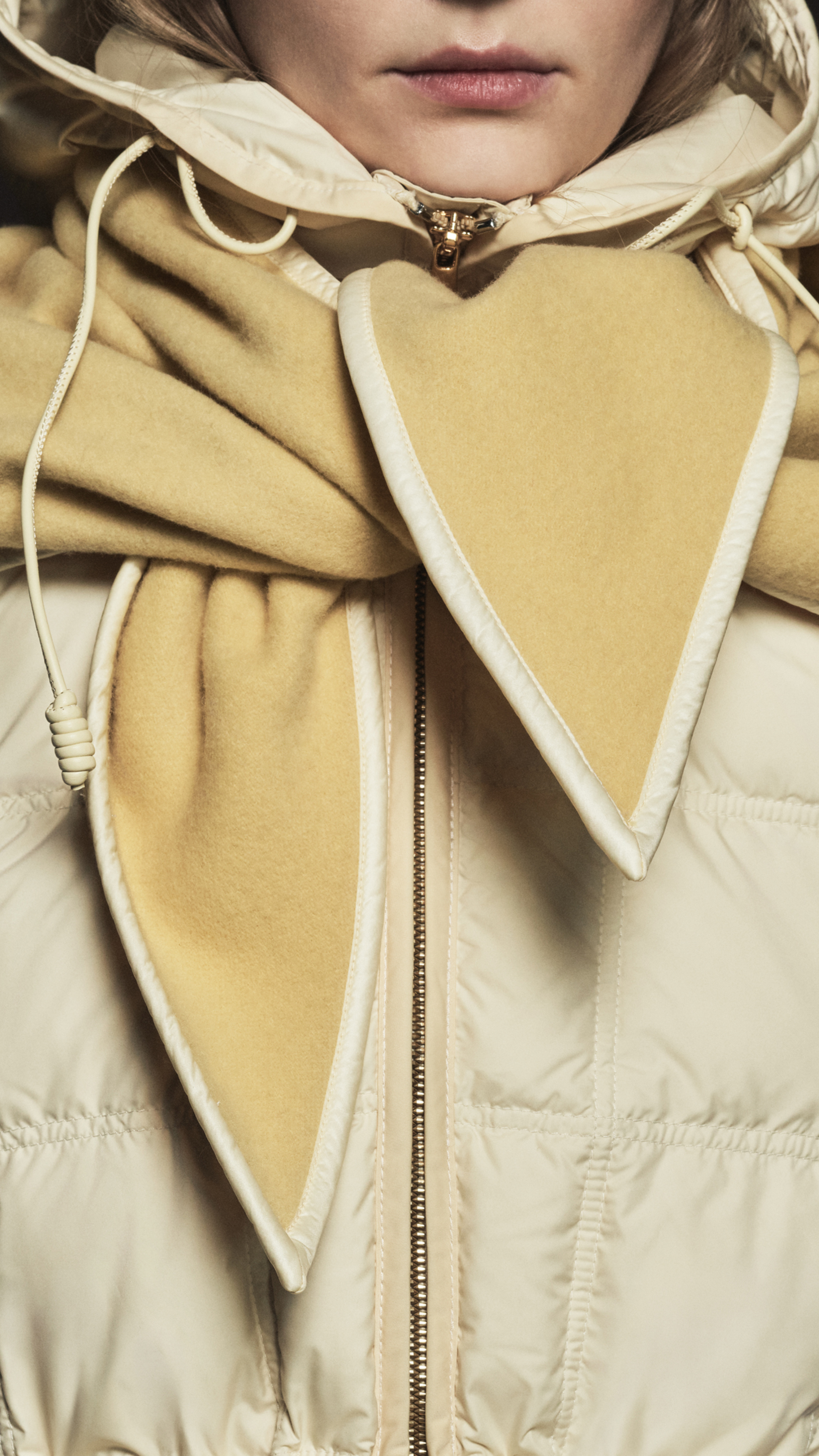 Moncler women's Fall WInter collection, beige puffer jacket and light yellow scarf. 