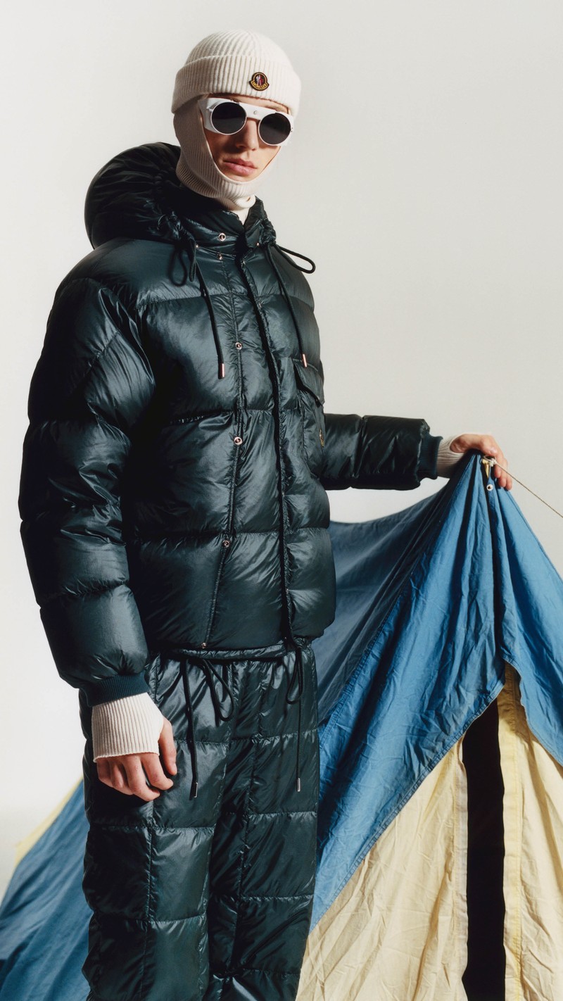 Moncler Re/Icons 2026, dark green Karakorum down jacket, cream balaclava, logo beanie and round sunglasses.
